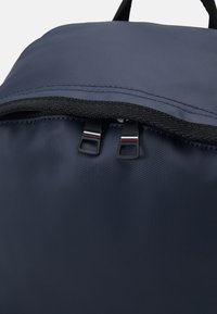 Zaino blu navy in tessuto nylon testurizzato, con una cerniera superiore a doppio cursore e un bordo della cerniera nero a contrasto.