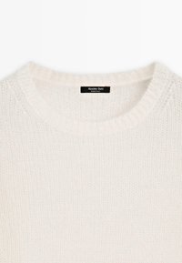Maglione lavorato a maglia color beige chiaro con collo rotondo, caratterizzato da una trama morbida e dettagli a costine sul collo. Etichetta che reca la scritta "Massimo Dutti, Made in Italy."