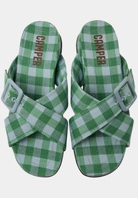 Le ciabatte a scivolo a quadri verdi e verde chiaro presentano cinturini incrociati con una fibbia grigia. La suola è marrone e ha una forma curva semplice.