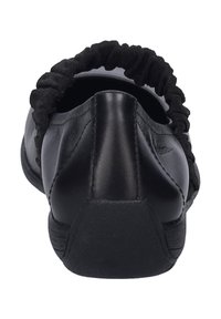 Chaussure noire en cuir à enfiler avec un accent élastique noir froncé à l'ouverture. Texture lisse et talon arrondi. Design de profil bas.