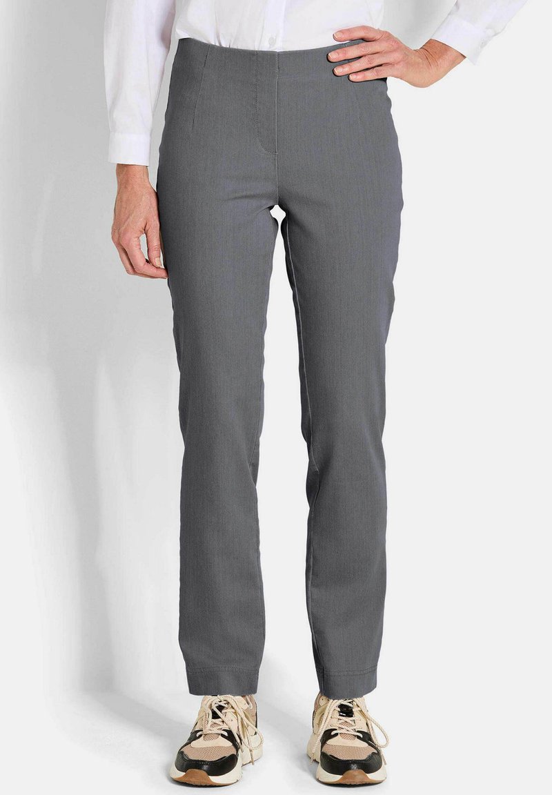 Grijze, aansluitende broek met een gladde textuur en rechte pijpen. G gedragen met beige en zwarte sneakers, met een klassieke, hoge tailleband.