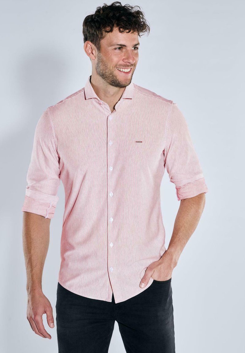 Rot-weißer gestreifter Langarmhemd mit Button-Down-Kragen, mit hochgerollten Ärmeln und einem kleinen Markenakzent in der Nähe der Brust.