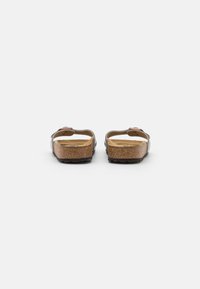 Brune korksåle sandaler med to justerbare stropper, glatt skinnoverdel og lett teksturert såle. Bakvisningen viser en flat design og gummisåle.