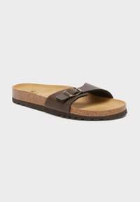 Sandalo scivolante in pelle marrone con una soletta in sughero imbottita. Presenta una fascia larga con una fibbia in metallo e una suola in gomma testurizzata.