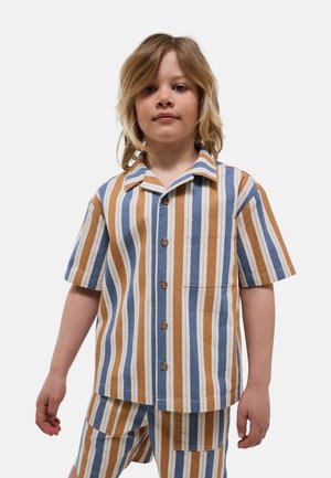Enfant aux cheveux blonds mi-longs portant une chemise boutonnée à manches courtes et un short assorti à rayures verticales bleues, blanches et beige.