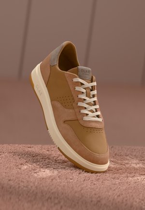 Sneakers in pelle marrone chiaro con accenti in suede beige, lacci bianchi, dettagli perforati e suola crema. Etichetta del marchio sulla linguetta.