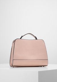 Strukturerad rosa läderhandväska med en texturerad yta, med en svart accent längs kanterna och ett kort handtag för bärande.