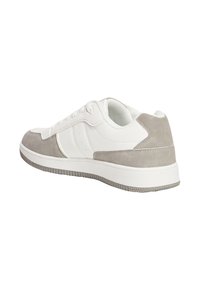 Sneaker bianca con accenti in suede grigio, dotata di una suola in gomma testurizzata, punta arrotondata e design con lacci. Piccole aperture di ventilazione sui lati.