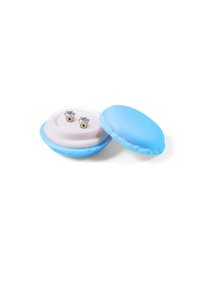 Custodia blu a forma di macaron con interni rosa chiaro, contenente due orecchini a perno in tono oro con pietre trasparenti e luccicanti.