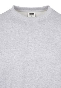 Sudadera orgánica de algodón gris con un cuello redondo acanalado, que presenta una textura suave y un sutil patrón jaspeado. Etiqueta visible en el interior del cuello.