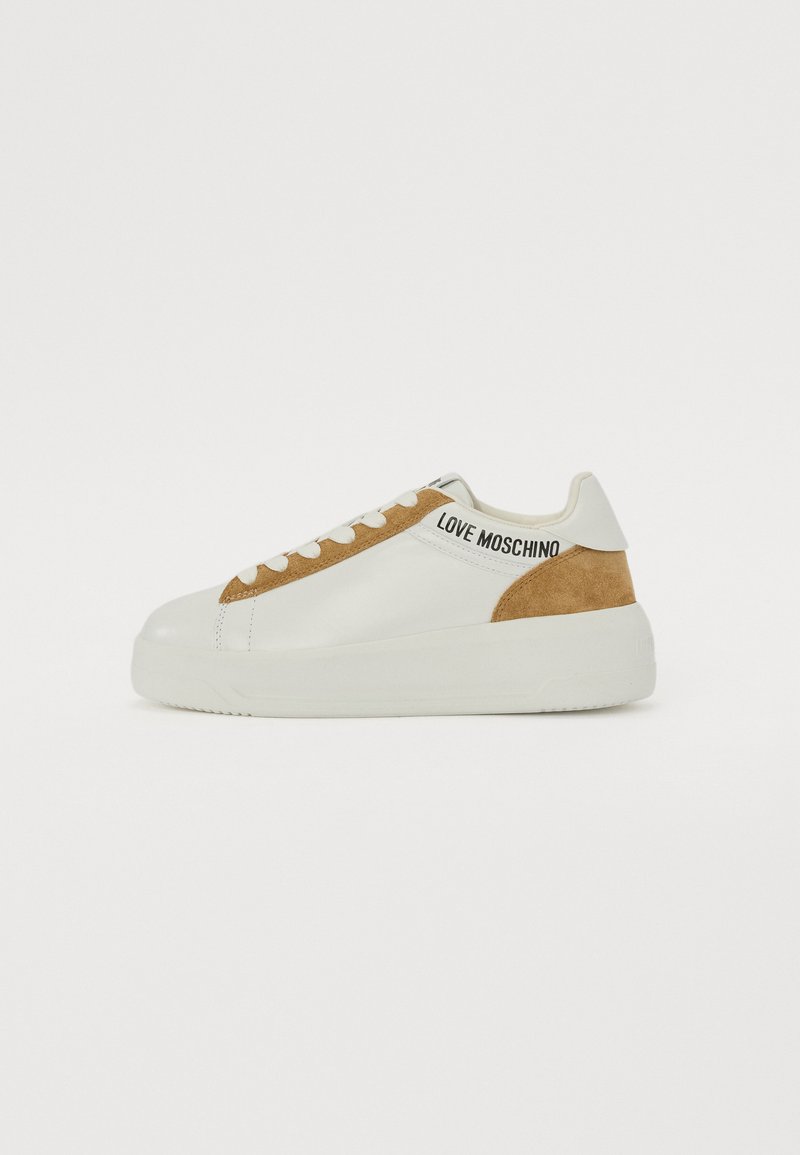 White leather sneakers with a tan suede accent, round toe, flat rubber sole, and "LOVE MOSCHINO" branding on the side.