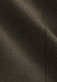 Tissu brun foncé lisse avec une texture subtile et une couture visible verticale sur le côté droit.