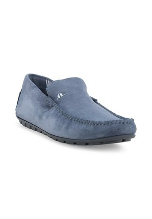 Mocassino slip-on in suede blu con suola in gomma nera e cuciture visibili lungo i bordi, inclinato per mostrare la parte frontale e laterale.