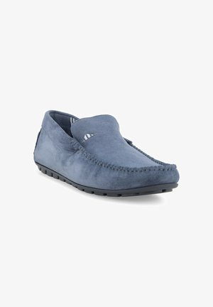 Mocassino slip-on in suede blu con suola in gomma nera e cuciture visibili lungo i bordi, inclinato per mostrare la parte frontale e laterale.