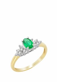 Anello d'oro con centro in gemma verde ovale, affiancato da ulteriori pietre trasparenti in una montatura tono argento con dettagli intricati.