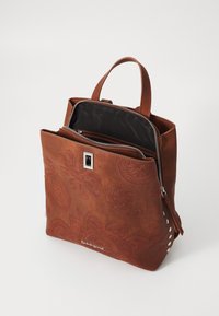 Ruskea nahkainen käsilaukku, jossa on kukkakuviot, vetoketjusulku, kaksi kahvaa ja sivustudsuja. Sisävuori on mustaa kangasta.