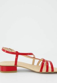 Czerwone lakierowane sandały na niskim klocku, z wieloma skrzyżowanymi paskami i regulowanym paskiem na kostkę z złotym zapięciem.