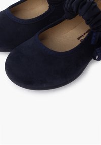 Ballerine in camoscio blu navy con punta arrotondata, dettaglio elastico arricciato sul tallone e soletta beige liscia.