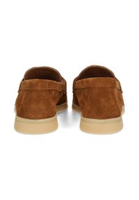 Bruine suède schoenen met een gladde textuur, met een laag profielontwerp en lichtgekleurde rubberen zolen. De achterkant toont stikseldetails.