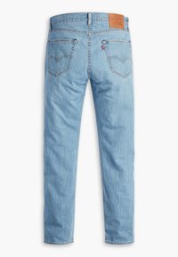 Light blue denim jeans with a straight cut, featuring a leather brand patch, two back pockets, and subtle fading throughout.