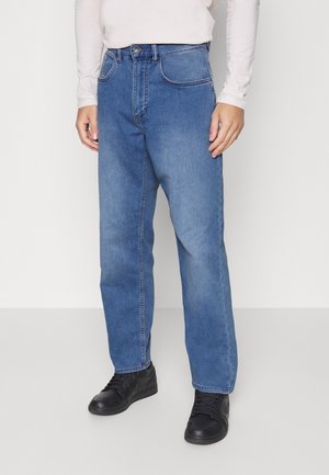 Jeans de denim azul com corte reto, apresentando bolsos frontais, um fecho de botão único e detalhes de costura em contraste.