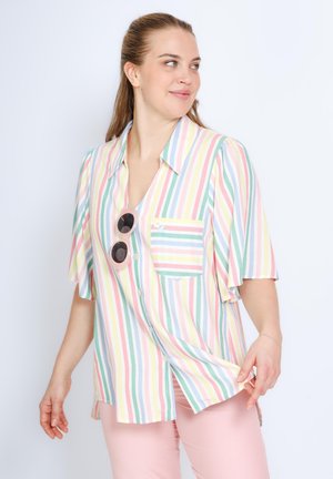 Gestreept T-shirt met korte mouwen in pastelkleuren, voorzien van een zak, knopen en een klein bloemenpatroon. Geaccentueerd met ronde zonnebril.