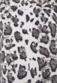 Leopard print fabric featuring a soft, fuzzy texture with black and grey spots on a cream background, highlighting the pattern's irregular shapes.