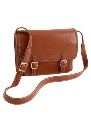 Besace en cuir marron avec deux sangles à boucles, bandoulière réglable et bords cousus sur fond blanc.