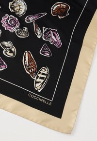 Écharpe en soie noire ornée d'illustrations colorées de coquillages en rose, blanc et brun, bordée d'un liseré crème avec l'inscription "COCCINELLE".