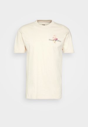 Kremowy t-shirt z krótkim rękawem z małym kwiatowym nadrukiem i napisem "House of Obey" na lewej piersi.