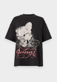 Μαύρο κοντομάνικο μπλουζάκι με μεγάλο φθαρμένο λευκό σχέδιο προσώπου λιονταριού, σχήμα καρδιάς και ροζ διακοσμητικό κείμενο "Puma" σε καλλιγραφικό στυλ μπροστά.