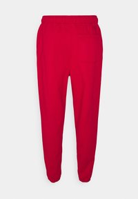 Rote Baumwoll-Sweatpants mit elastischem Bund, gerippten Knöcheln und einer einzelnen Gesäßtasche. Schlichtes Design ohne sichtbare Muster oder Akzente.