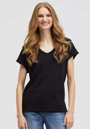 Black short-sleeve t-shirt with a relaxed V-neck design, made from soft fabric, featuring a loose fit and smooth texture, paired with blue jeans.