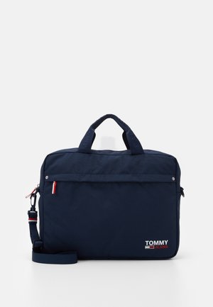 Sac d'ordinateur portable Tommy Jeans bleu marine avec double poignée, poche zippée avant, bandoulière détachable et logo en bas à droite.