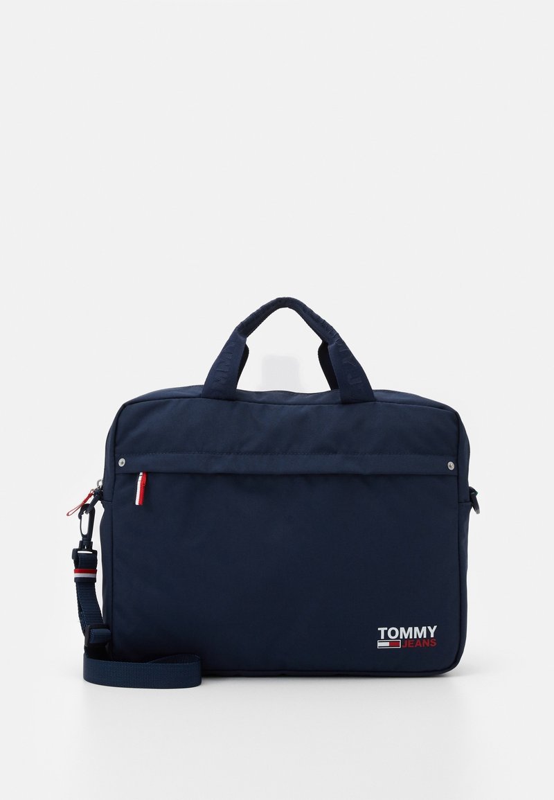 Sac d'ordinateur portable Tommy Jeans bleu marine avec double poignée, poche zippée avant, bandoulière détachable et logo en bas à droite.
