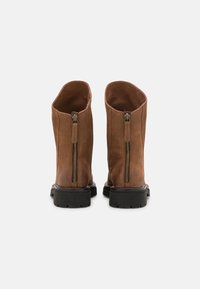 Botas de cuero marrón hasta el tobillo con un acabado suave, que cuentan con dos cremalleras en la parte trasera y una suela de goma negra resistente.