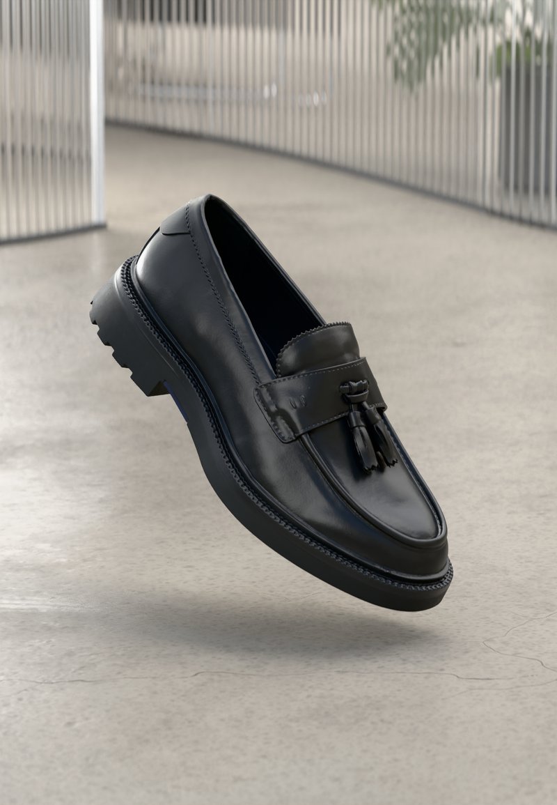 Black leather loafers with a smooth finish, decorative tassel, thick rubber sole, and stitched accents. Lightweight and sleek design.