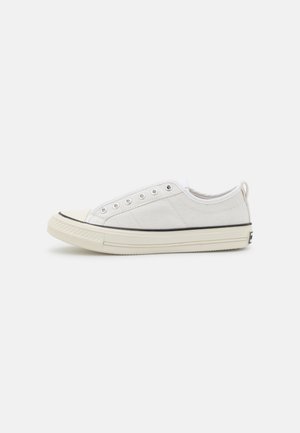 Zapatilla baja de lona blanca con ojales metálicos, suela gruesa de goma color blanco roto y franja negra de acento, vista de lado. Sin cordones.