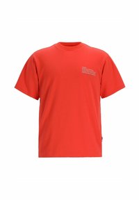 T-shirt rossa in cotone con maniche corte, scollo rotondo e scritta bianca stampata sulla parte anteriore in alto a sinistra. Design semplice e texture liscia.