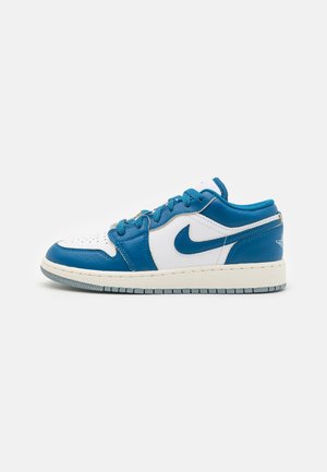 Le scarpe Nike Air Jordan 1 Low presentano una tomaia in pelle bianca con accenti blu, punta rotonda, lacci piatti e una suola in gomma testurizzata.