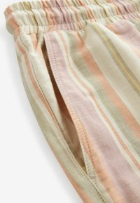 Tela rayada que presenta colores pastel de rosa, crema y verde; material de algodón suave con una cinturilla fruncida y detalle de bolsillo lateral.