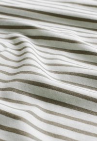 Helles beige und weißes Gewebe mit horizontalen Streifen, präsentiert mit sanften Falten und einer glatten Textur.