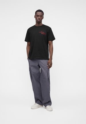 Calvin Klein Jeans, HERO ITALIC GRAPHIC UNISEX - Тениска с щампа - black