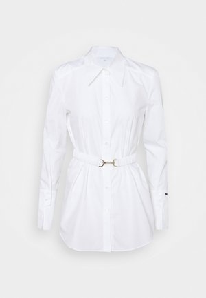 Vestido camisa blanco de manga larga con cuello puntiagudo, cierre de botones en la parte delantera, cintura elástica con hebilla plateada y botones en los puños.