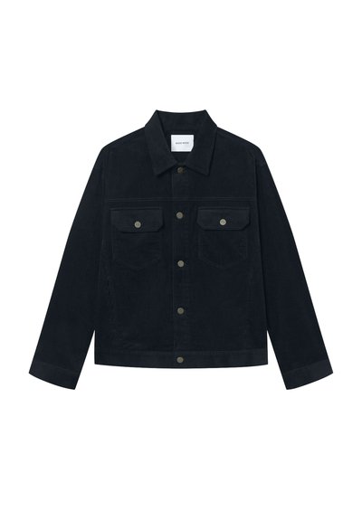 Tmavě námořnická manšestrová bunda s špičatým límcem, dvěma náprsními kapsami a kovovými patentkami. Rovný střih s dlouhými rukávy a ribbovanou texturou.