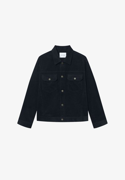 Tmavě námořnická manšestrová bunda s špičatým límcem, dvěma náprsními kapsami a kovovými patentkami. Rovný střih s dlouhými rukávy a ribbovanou texturou.