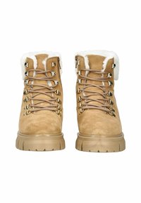 Stivaletti alla caviglia in suede tan con rivestimento in pelliccia sintetica, suola spessa beige, occhielli in metallo e lacci per una chiusura sicura.