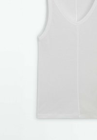 Hvid bomulds tanktop med dyb V-hals, glat tekstur og uden synlige mønstre eller udsmykninger. Simpelt, ærmeløst design.