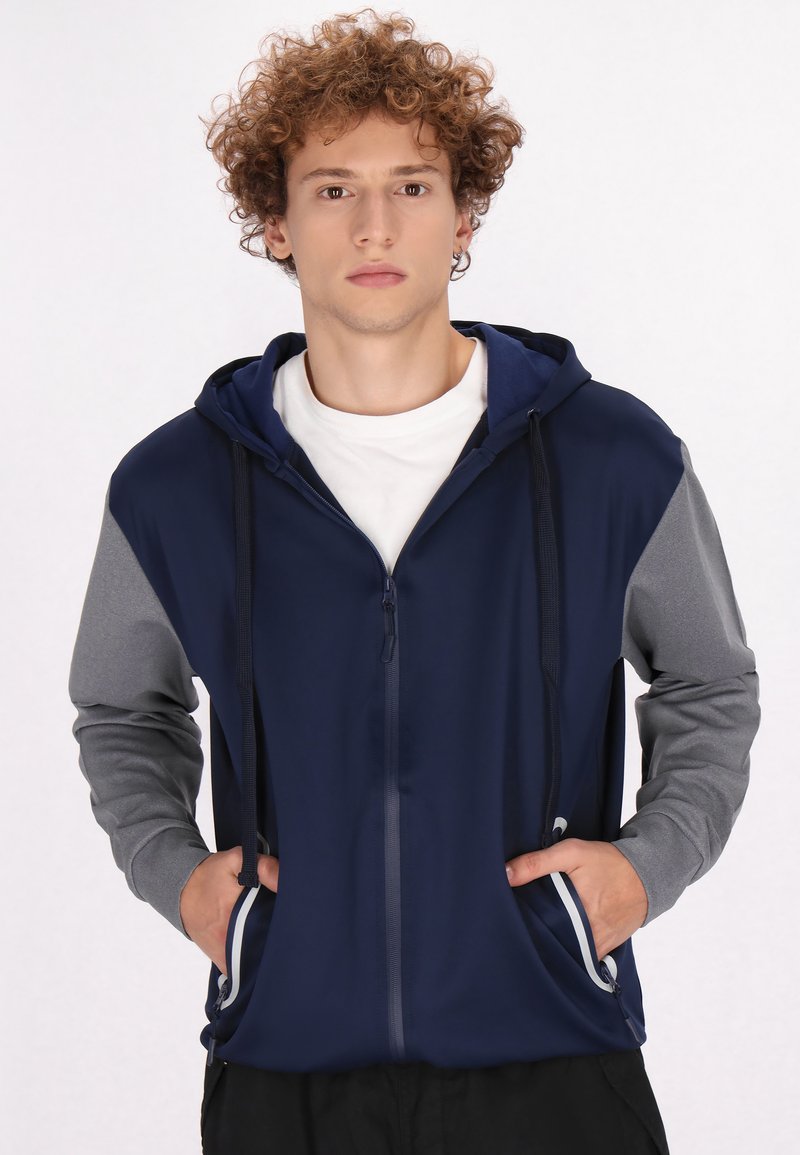 Felpa con zip in navy e grigio, dotata di cappuccio con lacci, tasche laterali e colori delle maniche a contrasto; realizzata in tessuto morbido e flessibile.