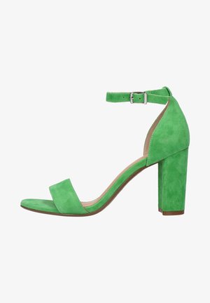 Groene suède hoge hak sandaal met een vierkante neus, een enkele enkelband met een gesp en een dikke hak. Glad oppervlak overal.